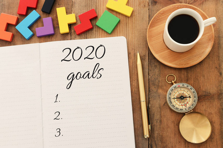 top view 2020目标清单的商业理念，配有笔记本电脑一杯咖啡放在木制桌子上