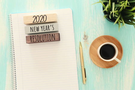 top view 2020年解决方案清单的商业理念，带笔记本电脑，蓝色木制桌子上的咖啡杯