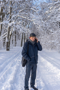 真实森林一个英俊的中年男人在冬天的雪地公园或森林里散步.