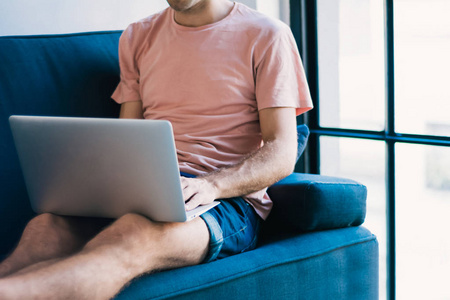 Young man relaxing on the sofa with a laptop 