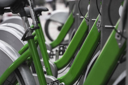 街道交通绿色混合动力出租自行车，电子支付形式，适合在城市周边出行，在出租网络停车场排队等候骑自行车的人出行。