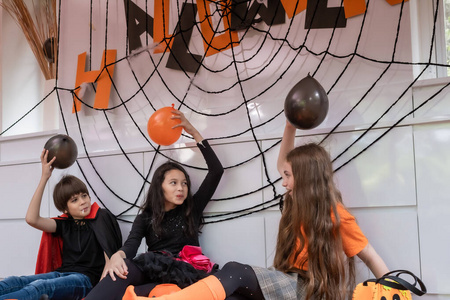 Girl and boy kids dress up as Halloween vampire costume holding 