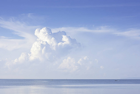 渔船在海上行驶,云朵在天空中飞舞.照片