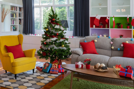 客厅的黄色大椅子，带圣诞树和礼品预售