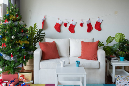 Empty living room is decorated with Christmas tree and gift pres