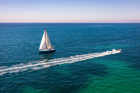 White sail boat isolated in blue sea water. Sailboat in the sea 