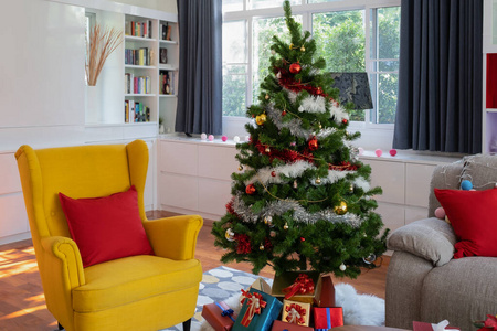 客厅的黄色大椅子，带圣诞树和礼品预售