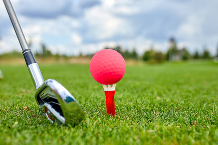 高尔夫球场上球洞里的球。高尔夫概念。击球前高尔夫球杆旁边草地上高尔夫球的特写镜头。