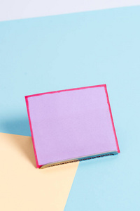 倾斜放在缓冲线上的一张纸，背景柔和。空白的素色桌子边上有一张便笺。平面摄影编排的艺术方法