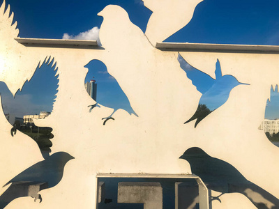 蓝天前用金属雕刻的鸽子的抽象轮廓