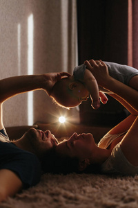 婴儿和他的父母在床上玩耍。家庭幸福。生活舒适的照片。4个月大的小男孩