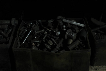 不同尺寸的螺栓和螺母放在一把暗色钥匙里的盒子里