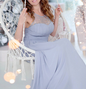 girl in a blue dress swinging in a round swing in the New Year 