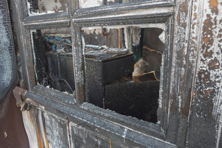 Charred window of a burnt house 