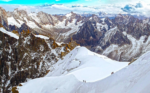 在法国夏蒙尼的勃朗峰，阿尔卑斯山，两组登山者正在攀登雪冰川斜坡。