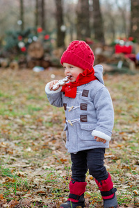 小男孩在公园的户外玩耍和吃饼干。在寒冷的日子里，孩子们在外面玩耍。