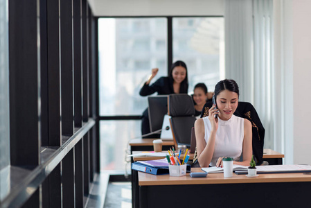 Business woman talking on the mobile phone while sitting at her 