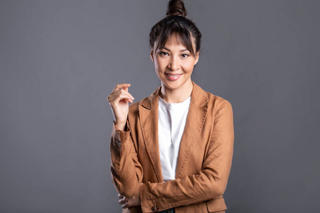 Young asian business woman on gray background. 