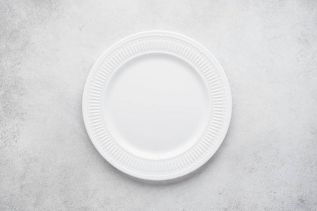 Empty round plate on light gray concrete background.