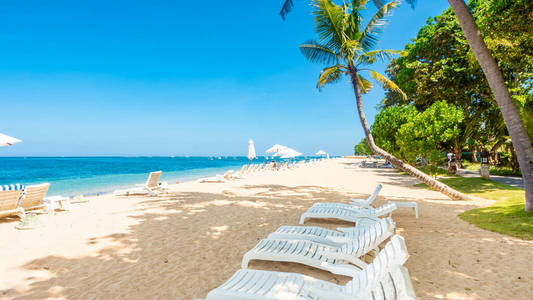阳光明媚的热带海滩上的躺椅。