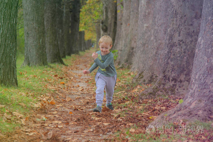 可爱的孩子，在秋天的街上玩得开心，蹦蹦跳跳的