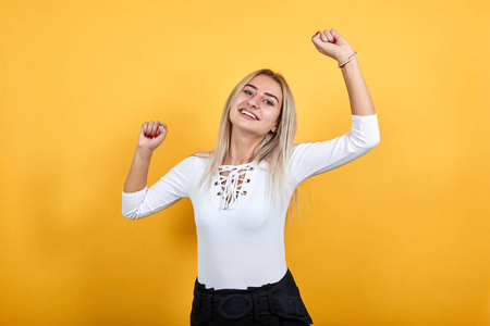 美丽的年轻女孩越过孤立的白墙,双手握拳照片