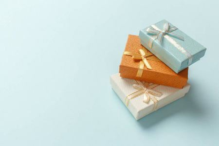 小礼品盒堆放在柔和的绿松石背景上。圣诞礼物。