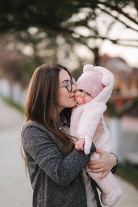 年轻的母亲带着她的小宝宝。妈妈用手抱着孩子。幸福的家庭