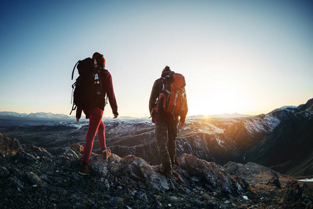 两个徒步旅行者在日落山脉散步