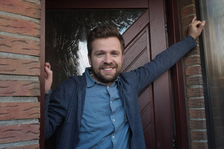 微笑的年轻人向他的朋友开门.照片