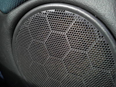 音响孔汽车里的音乐喇叭发出的灰色烤架.汽车内部.音响立体声扬声器.