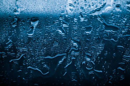 水的纹理抽象背景，水滴在蓝色玻璃上