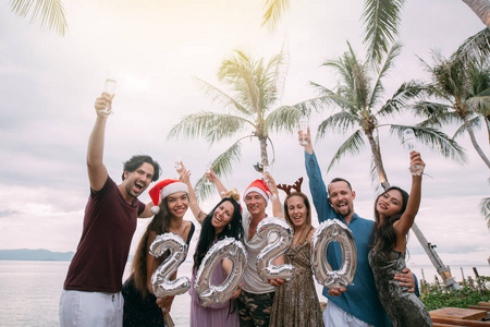 A large company has fun with champagne by the ocean in the tropi