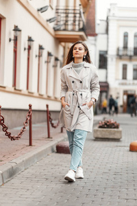 Pretty attractive young woman in fashionable clothes walks along