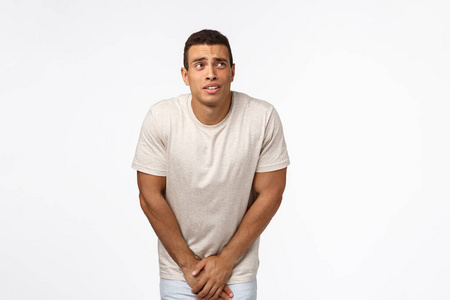 站在白色的背景下不舒服又不耐烦男人排尿采用公众的公用厕所男性的尿