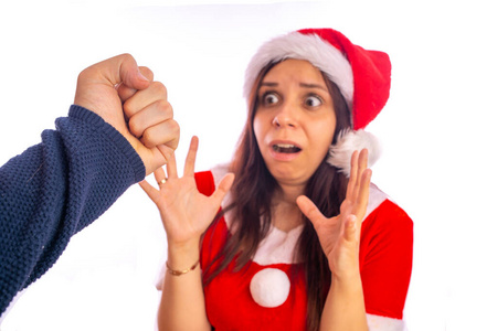 吓坏了的男人一名男子正在用拳头打穿圣诞老人制服的受惊妇女的脸.