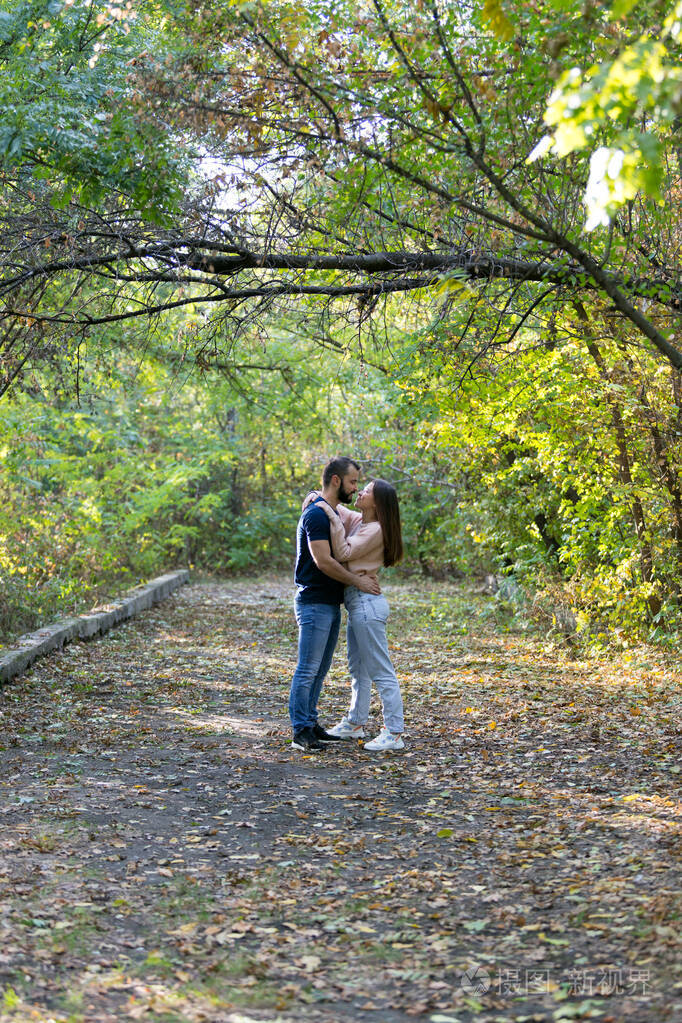 一对相爱的年轻夫妇在公园里拥抱亲吻.男人和女人单独在一起