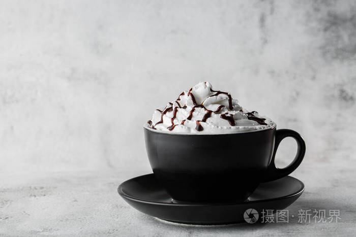 加奶油和巧克力面层的咖啡。在明亮的大理石背景上单独放置在深色杯子里的冰布奇诺。俯视图，复印空间。咖啡菜单广告。咖啡店菜单。水平p