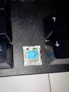 桌上带蓝色开关的机械键盘。