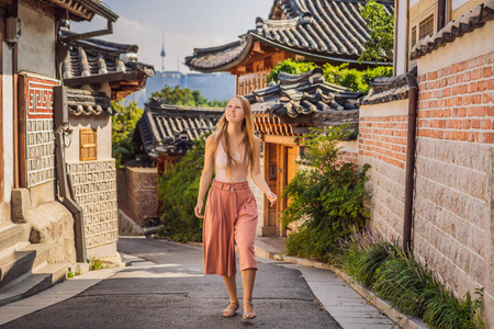 布克冲河内村的年轻女游客是著名的韩国传统民居保存地之一。韩国旅游概念