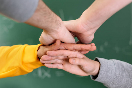 学生们在学院里双手合十，背景是黑板。