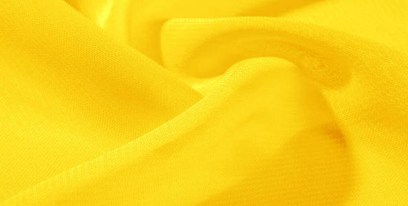 纹理背景图案黄色丝绸面料。这件丝绸欧根纱