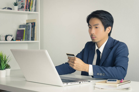 亚洲商人用复古风格的信用卡在线购物