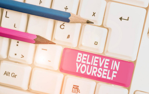 文字标志显示相信你自己。概念照片鼓励某人自信的动机引用白色电脑键盘上的空白笔记纸白色背景键复制空间。