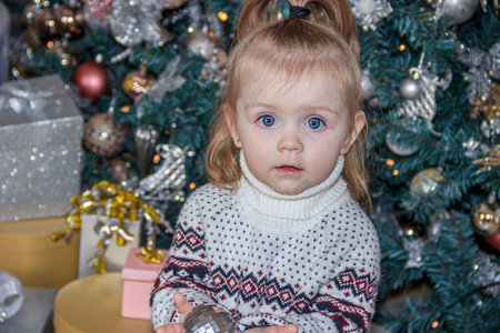 圣诞树旁的可爱小女孩。新年和圣诞节。圣诞树装饰。