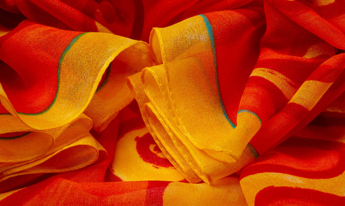 texture silk, fabric red background with painted yellow flowers 