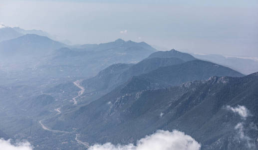 美丽的剪影全景山在蓝色色调与薄雾和云。