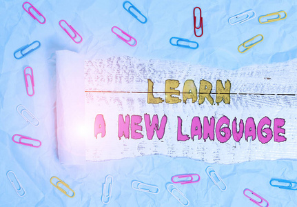 写笔记，展示学习一门新语言。商业照片展示学习单词以外的母语回形针和撕碎的纸板木制经典桌子背景。