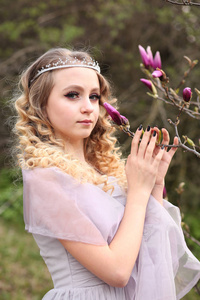 young beautiful girl in a light lilac dress in the garden where 