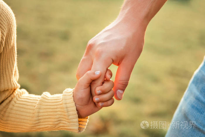 父女大人和黄衣小孩儿手牵手信任